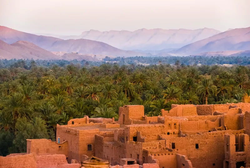 Kasbah di terra cruda e palmeto, con le montagne sullo sfondo